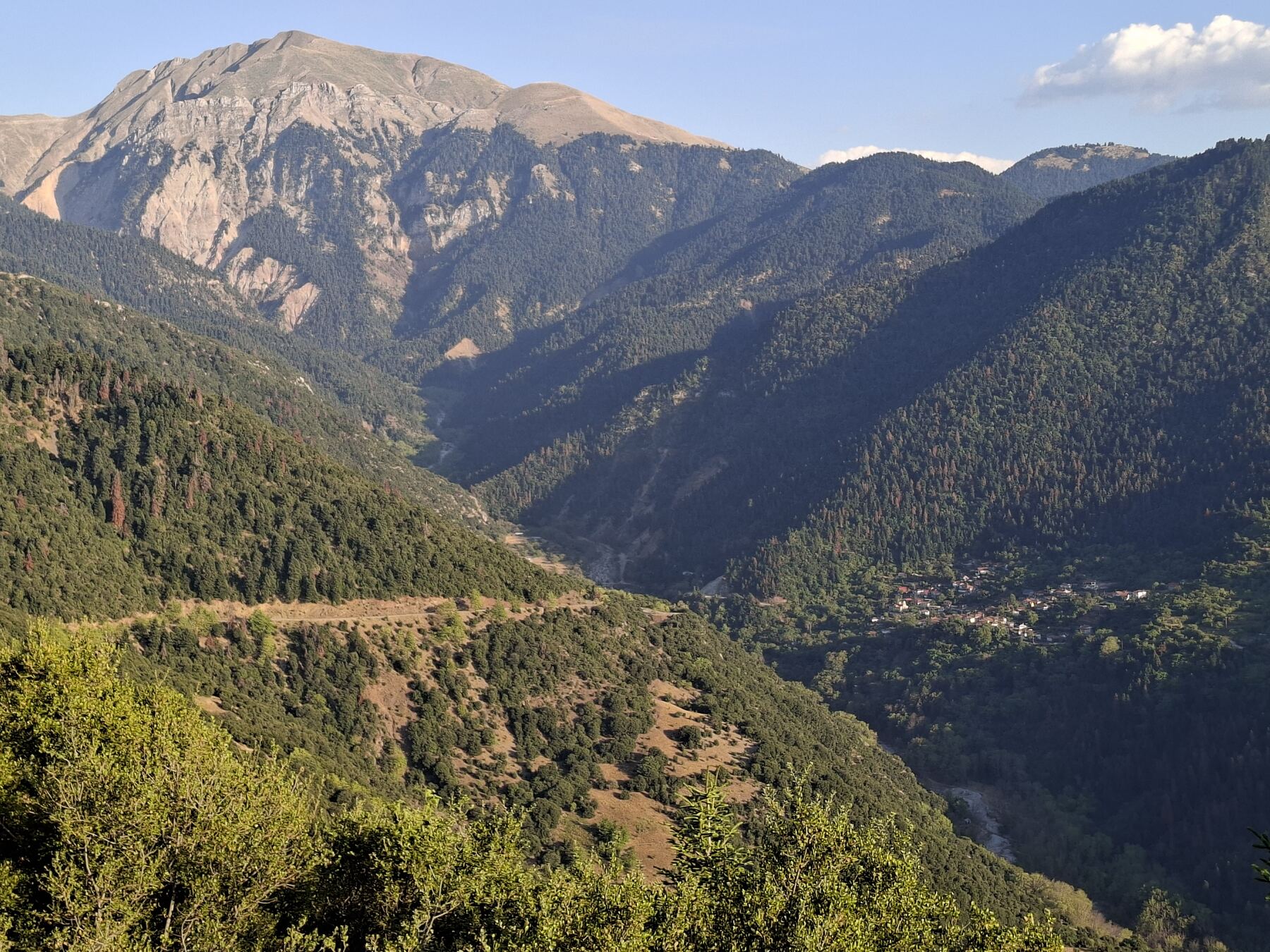Το Στένωμα στην πλαγιά, με τις κορυφές του Βελουχιού πίσω και τη χαράδρα του Στενωματιώτη